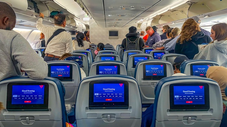 passengers debarking Delta plane with seatback screens