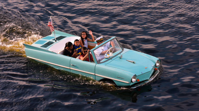 Amphicar cutting through water at Disney Springs.