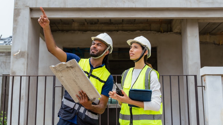 Two people working on housing plans