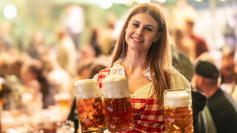 woman carrying steins of beer in Austria Oktoberfest