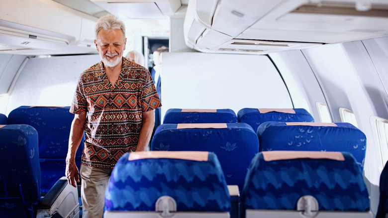 elderly man walking on plane
