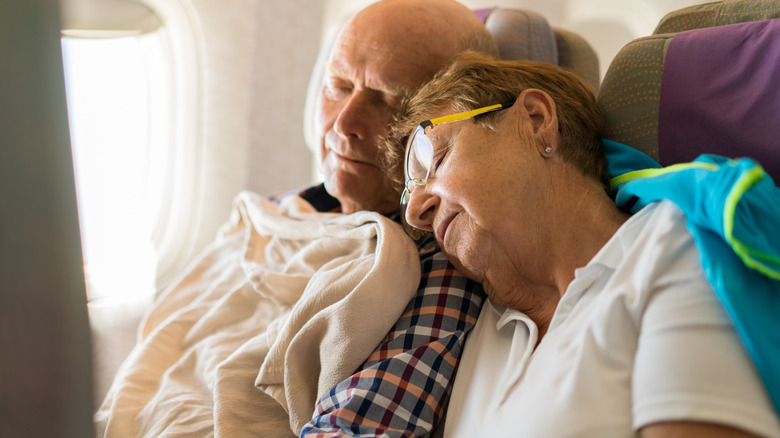 elderly couple sleeping on plane