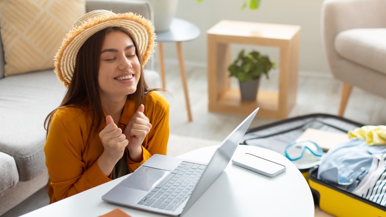 happy traveling woman using computer