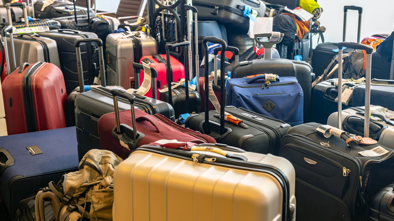 A large pile of luggage, including suitcases of multiple colors