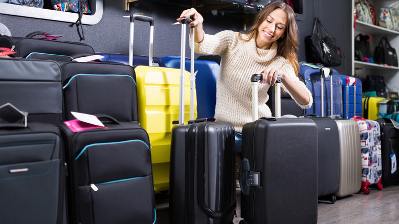A woman at a store shopping for budget-friendly luggage