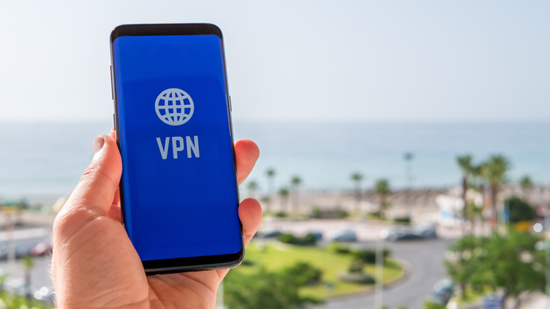 A phone connecting to a VPN with a seaside town in the background