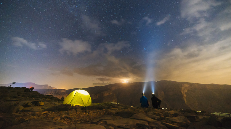 Two campers gaze at an evening sky in the desert