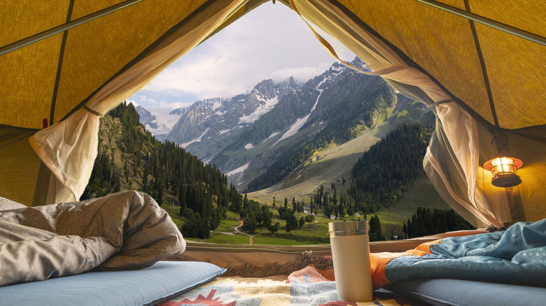 An unzipped tent reveals beautiful alpine scenery