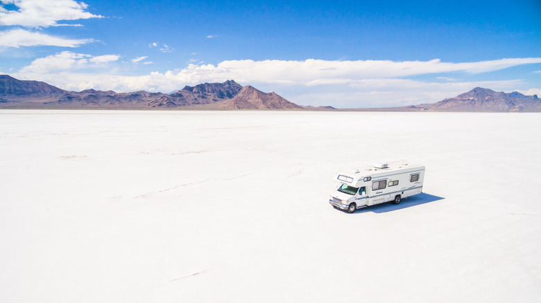 An RV is parked in the middle of salt flats