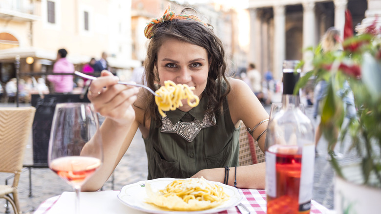 Woman eating pasta in Rome