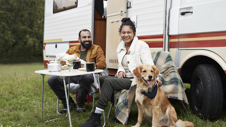 Couple with baby and dog outside RV