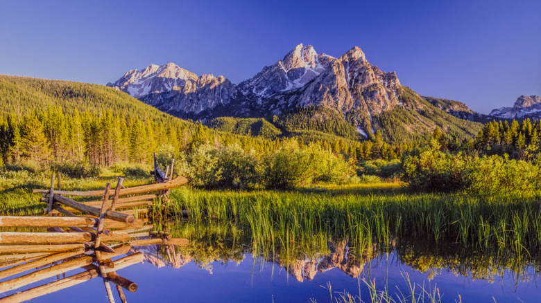 snow capped mountains reflected in still lake water in the Idaho countryside