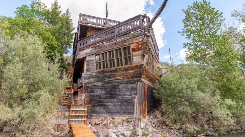 An airbnb disguised as a pirate shipwreck in a lakeside cove