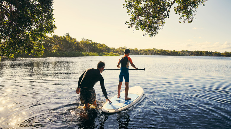 Son and father paddle boarding