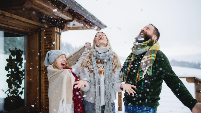 Family enjoys snow at a cabin