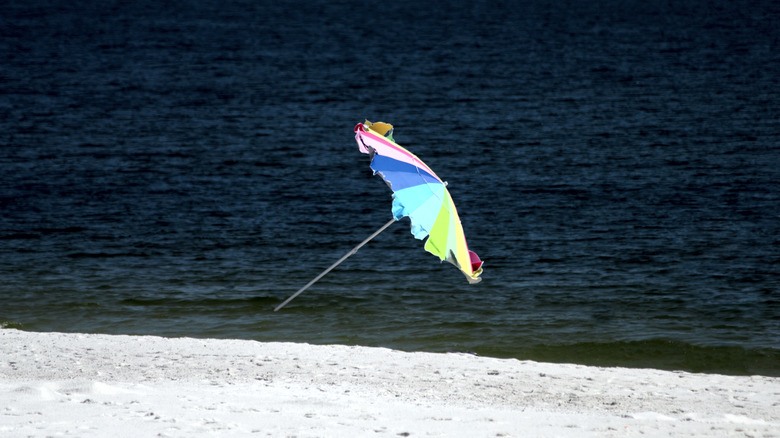 A beach umbrella taking off in the wind