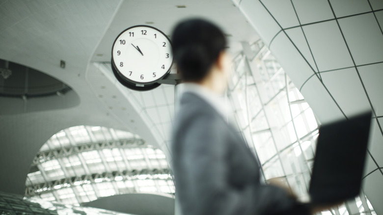 person looking at clock in a train station or airport