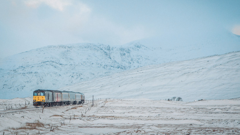 Train crossing snowy mountains in Scotland