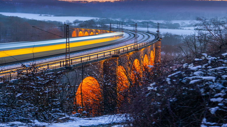 Long exposure of train on viaduct at winter sunset