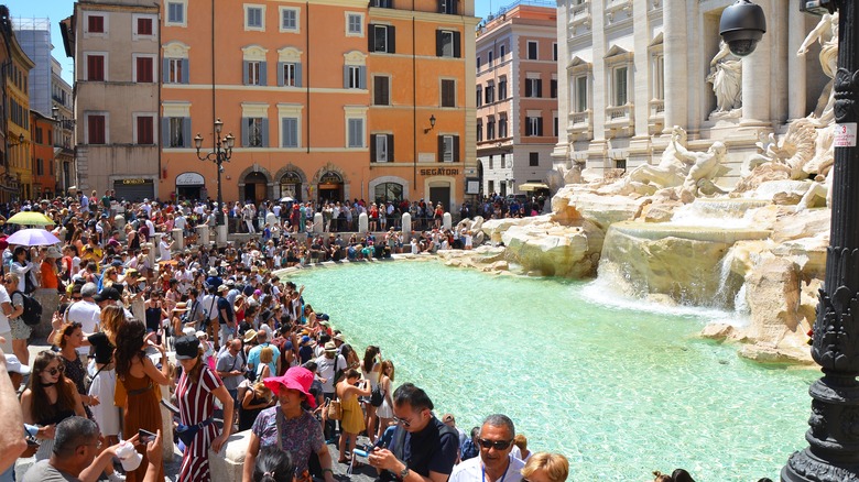 Crowds of tourists around the Trevi Fountain in Rome