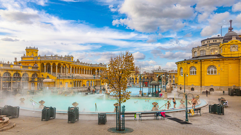 Yellow buildings and pale blue steamy pool at Szechenyi Baths, Budapest, Hungary