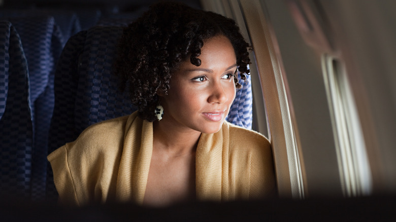 A woman looking out of a plane window