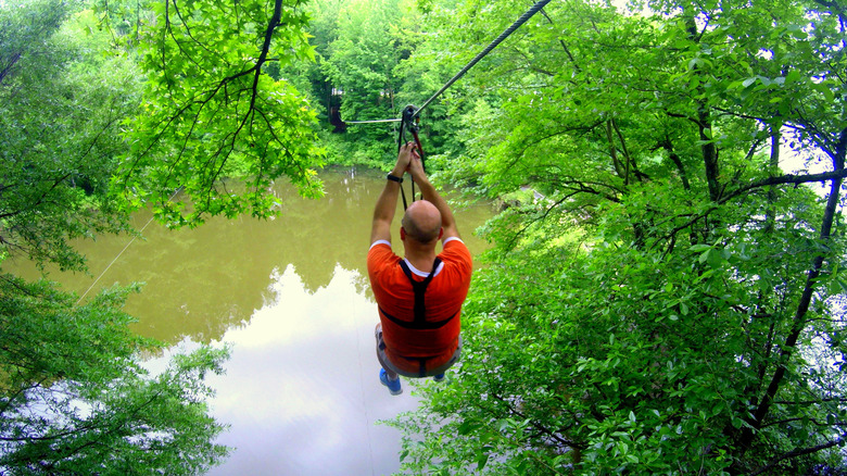 Man ziplining at Lums Pond