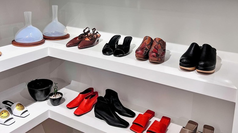 Multiple pairs of shoes displayed on two store shelves