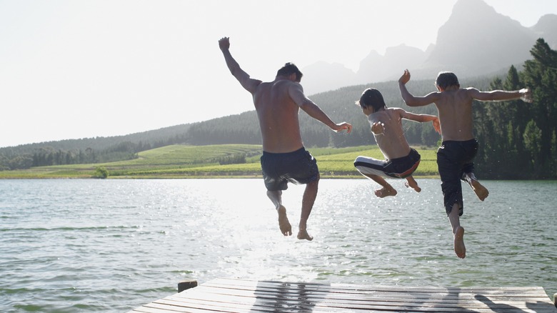 Boys jumping into a lake