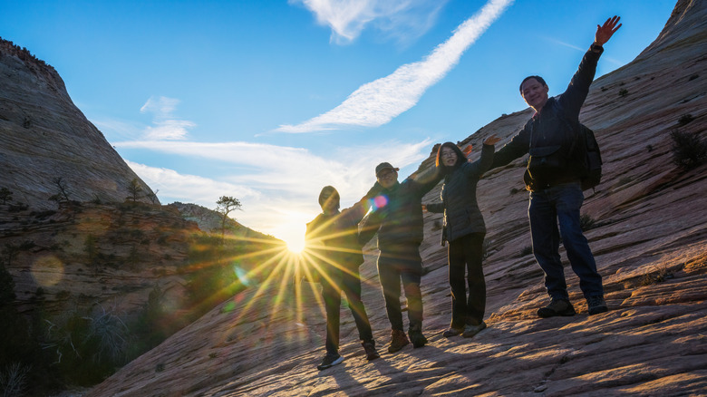 A group of people hiking in Zion at sunset