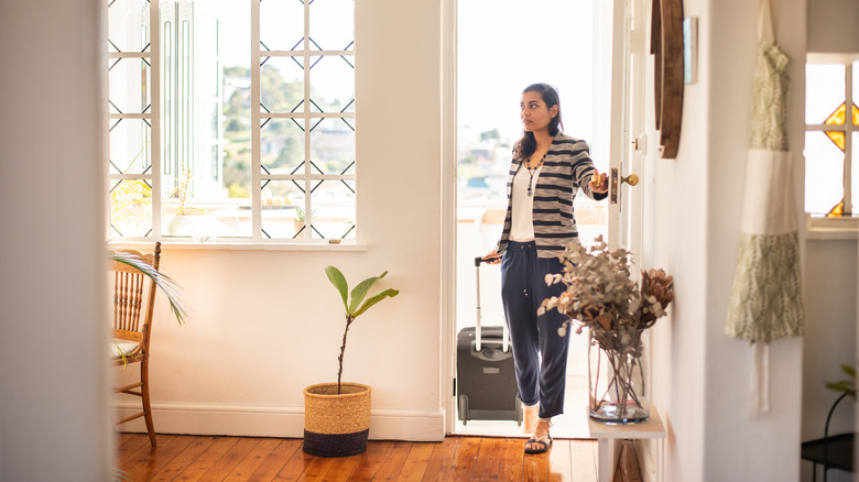A woman with a suitcase entering into a vacation rental
