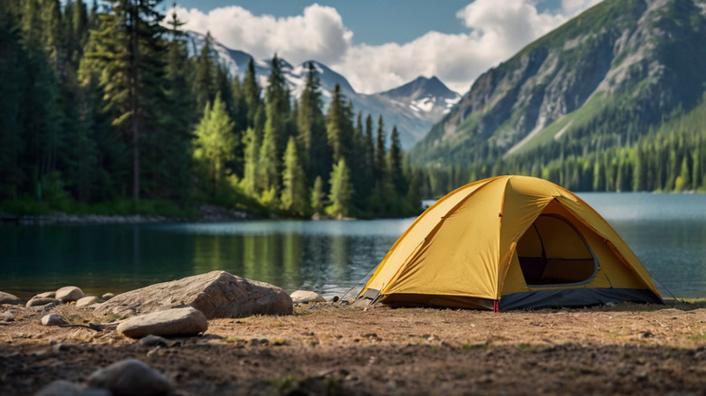 yyellow tent on waterfront campsite with mountain views