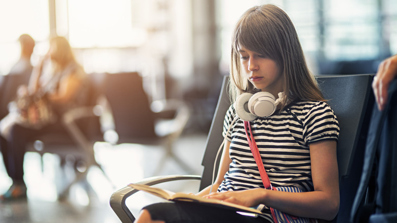 Teen reading at the airport
