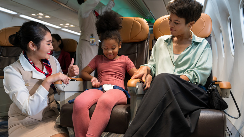 flight attendant talking to child and parent