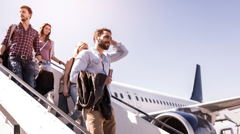 Passengers leaving a plane via the staircase