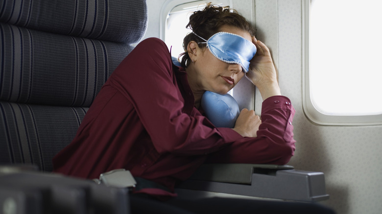 Airplane passenger sleeping against window