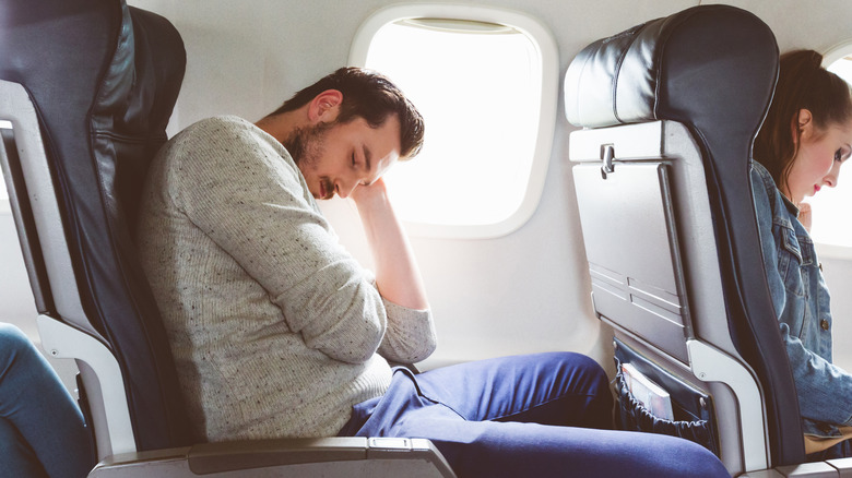 man sleeping on airplane