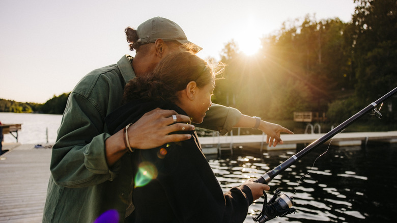 father and daughter fishing together on dock