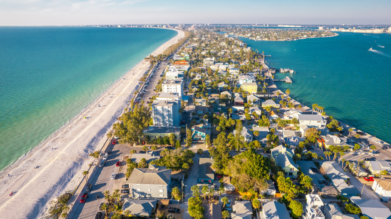 Aerial view of buildings along the strip of white sand on St Pete Beach barrier island