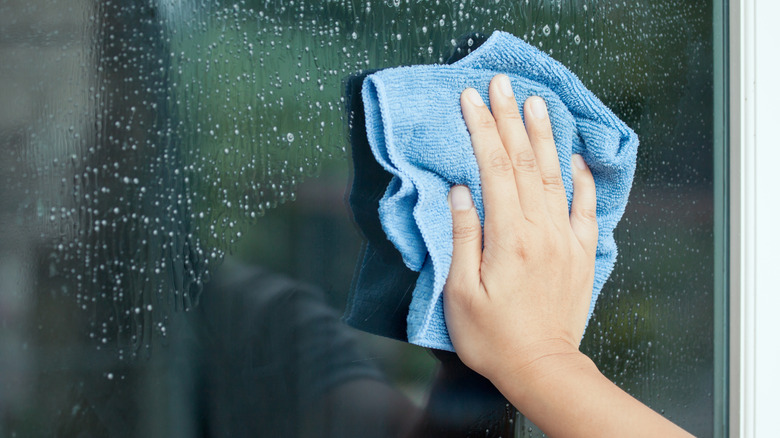 cleaning a window with rag