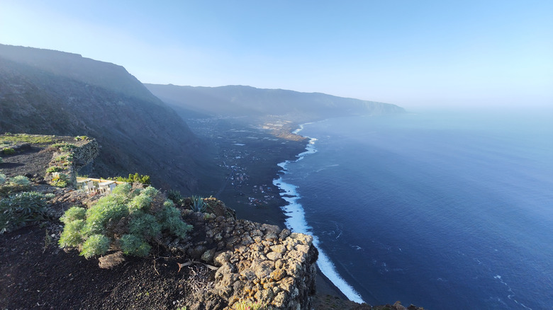 A black volcanic-sand beach backed by mountains in El Hierro.