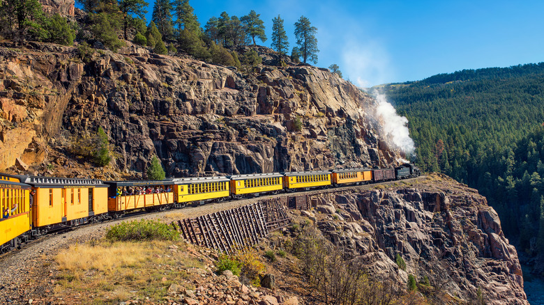 Historic yellow train traversing the San Juan Mountains of Colorado between Durango and Silverton above a steep gorge