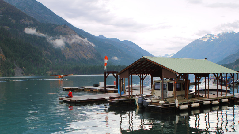 Boat at a covered pier on Chelan Lake surrounded by mountains