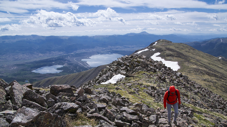 Mountain ridgeline overlooking lake with a hiker