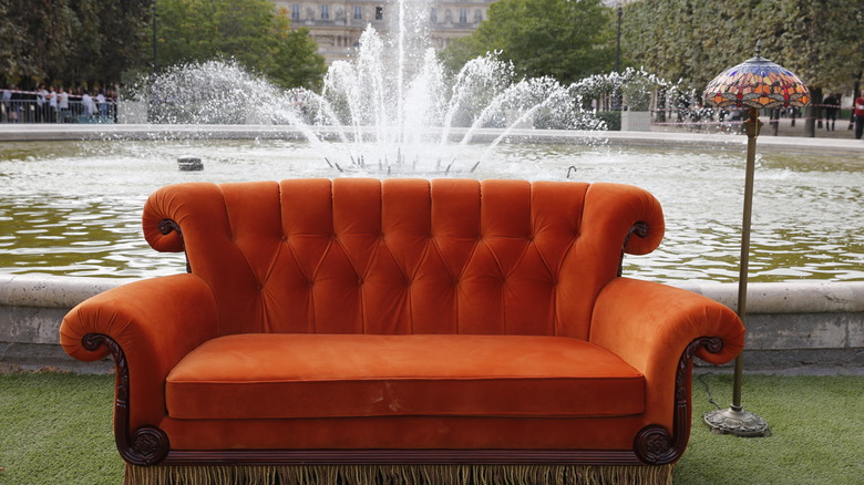 orange couch in front of fountain