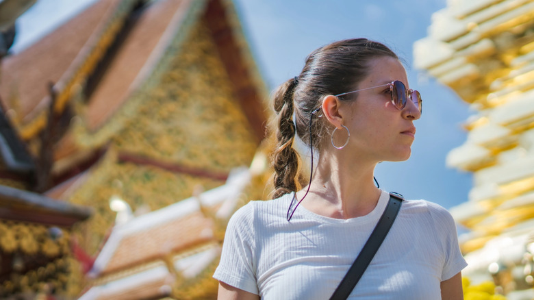 A stylish gen z influencer visits a Thai temple