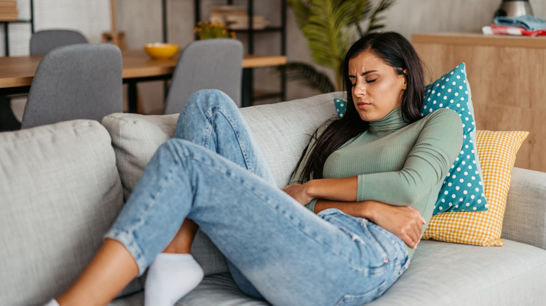 Young woman clutching her stomach