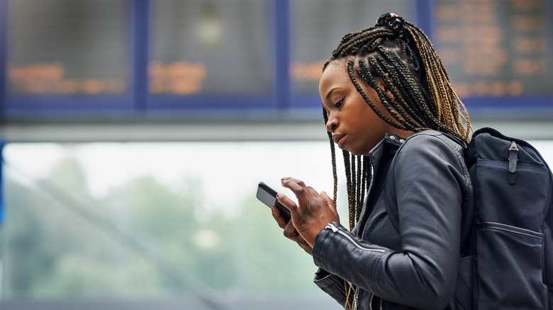 Woman using her phone at airport