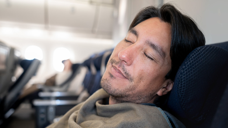 man sleeping on plane