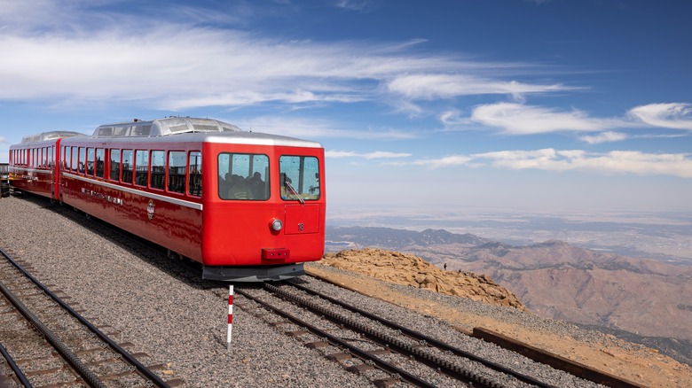 The Cog chugging along a railroad track with mountains in the background